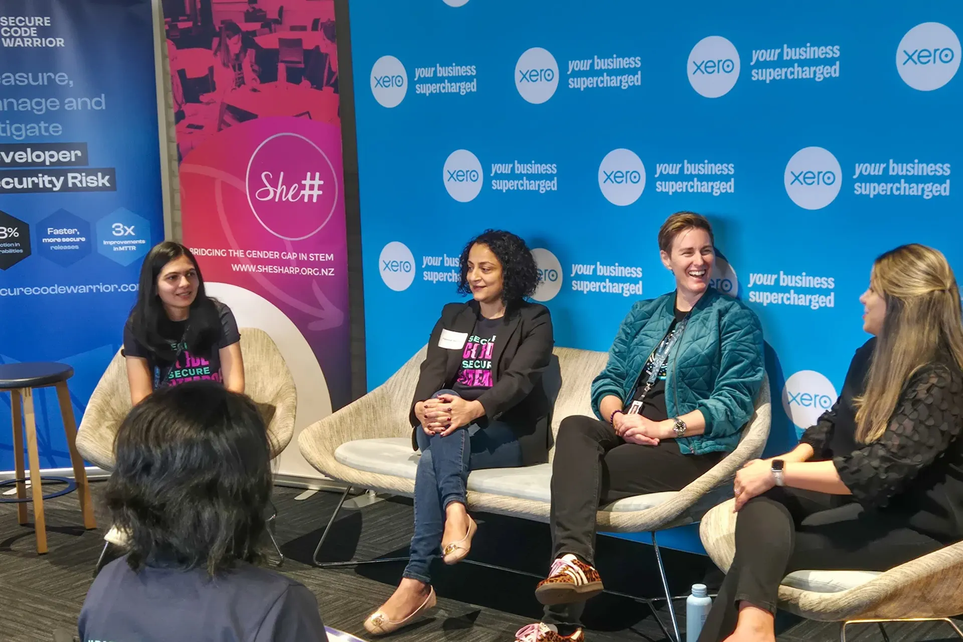 A panel of women seated in armchairs during a She Sharp fireside discussion.